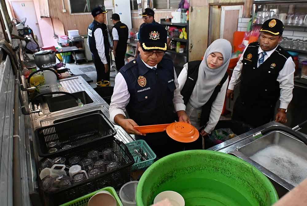 Pasukan kesihatan memeriksa bahagian dapur yang digunakan oleh pemilik premis kedai makan dalam Operasi Cakna Undang-Undang Kesihatan Awam Siri 2/2024.