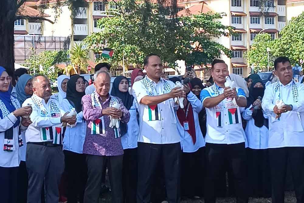 Muhammad Nasir (tiga dari kiri) bersama Mohd Hafiz (tengah) ketika program melepaskan hampir seratus burung merpati ke udara sebagai tanda solidariti kepada Palestin.