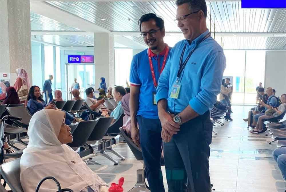 Kamaruzzaman (kanan) beramah mesra dengan penumpang semasa beliau turun padang meninjau hari pertama operasi terminal baharu LTSIP di Kota Bharu pada Rabu.