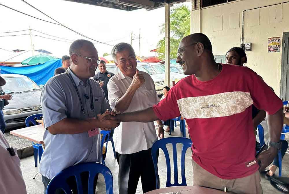 Khairul Azhari (kiri) sempat beramah mesra bersama penduduk setempat ketika berkempen di sekitar Kuala Kubu Baharu.