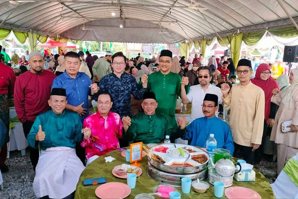 Khoon Hai (duduk: dua dari kiri) bergambar bersama Muhanmad Fauzi (duduk: dua dari kanan) dan tetamu yang hadir pada Majlis Rumah Terbuka Aidilfitri Pas Pulau Pinang, pada Rabu.