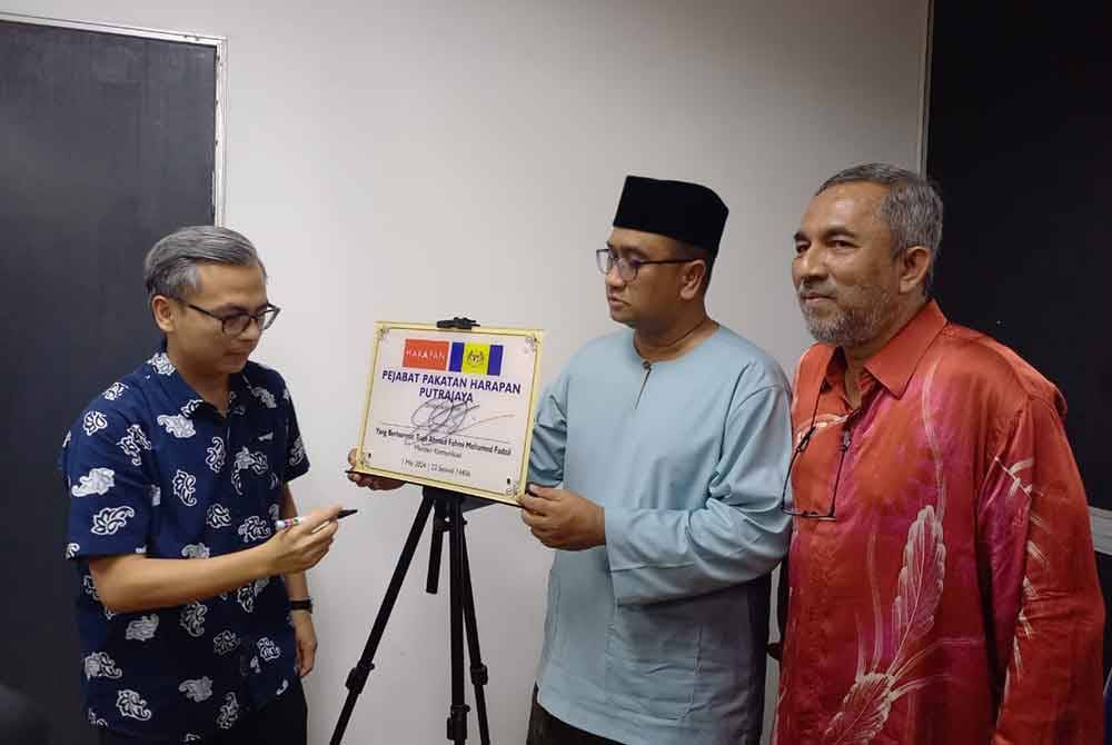 Fahmi Fadzil (kiri) ketika merasmikan pejabat Pakatan Harapan (PH) di Presint 11, Putrajaya pada Rabu.