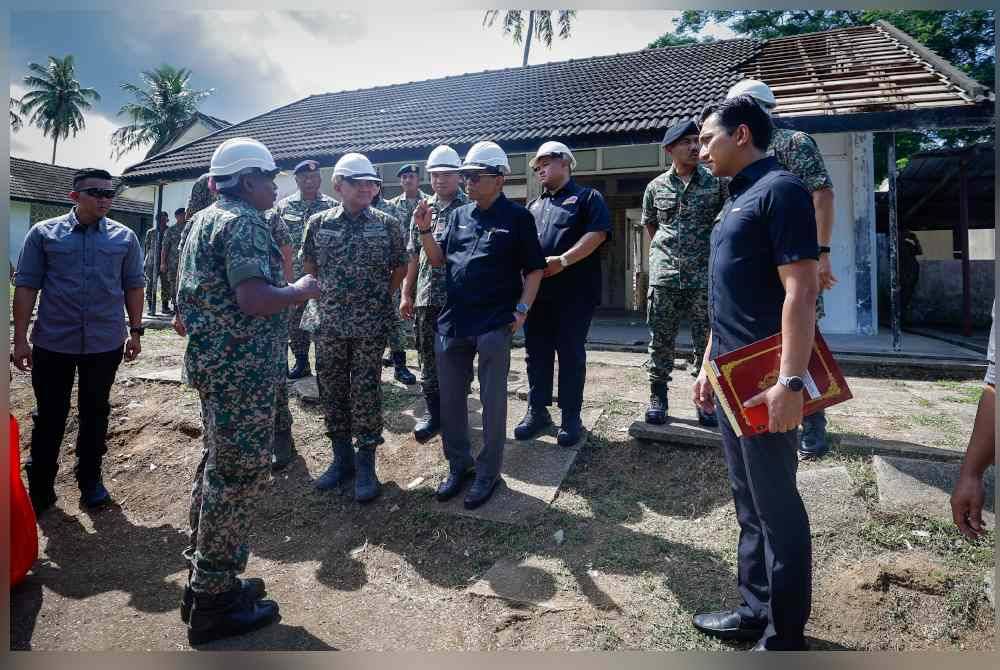 Mohamed Khaled (tengah) melawat salah sebuah Rumah Keluarga Angkatan Tentera (RKAT) yang dalam proses baik pulih sempena lawatan kerja beliau di Kem Terendak, Sungai Udang hari ini. Foto Bernama