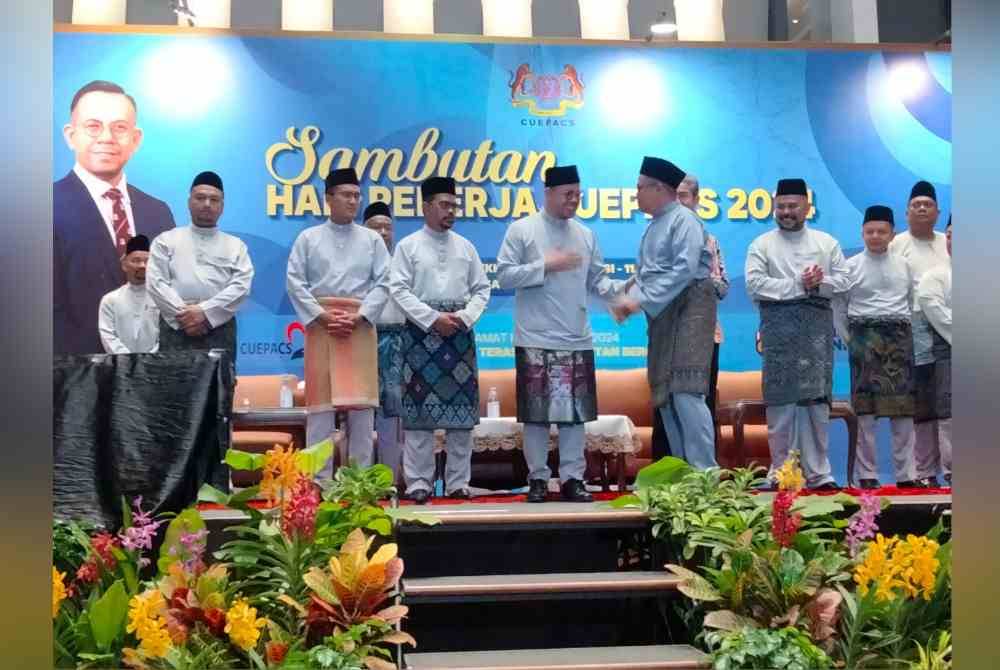 Steven Sim (tengah) dan Adnan (empat kiri) menyampaikan anugerah kepada pekerja cemerlang pada sambutan Hari Pekerja Cuepacs Tahun 2024 di Pusat Konvensyen Majlis Bandaraya Shah Alam (MBSA) pada Rabu.