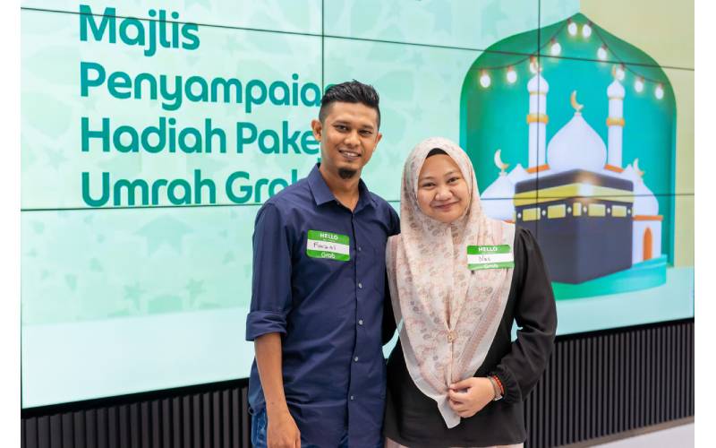 Faizal yang sudah menjadi rakan- penghantar Grab sejak 2021, bersama isterinya, Nas di majlis penyampaian hadiah Cabaran Ramadan-UmrahGrab.