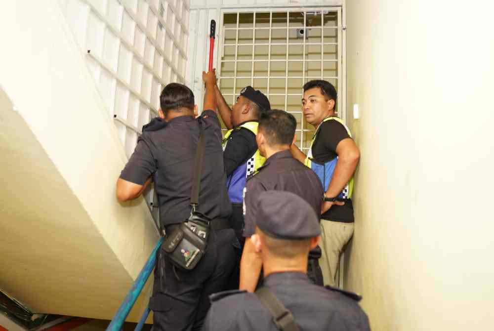 Penguat kuasa MPS memecah pintu premis selepas pekerja enggan memberikan kerjasama sewaktu pemeriksaan dijalankan di Desa Aman Puri, Kepong. pada Selasa.