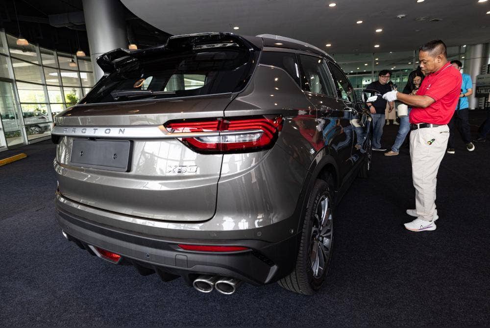 Juruaudit Proton, Nari Azahar Baserah (kanan) melakukan penilaian ke atas kenderaan Proton X50 pada Sesi Taklimat Inisiatif Kualiti Proton di Kilang Proton pada Khamis. Foto Bernama