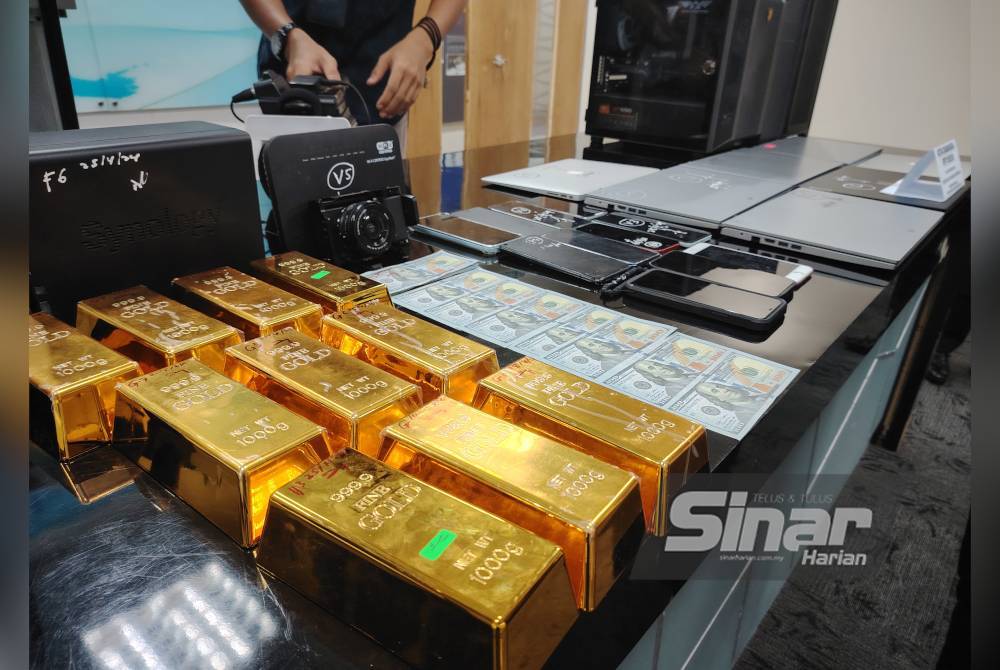 Replika jongkong emas dan duit palsu yang dirampas polis dalam serbuan di Petaling Jaya pada 25 April lalu.