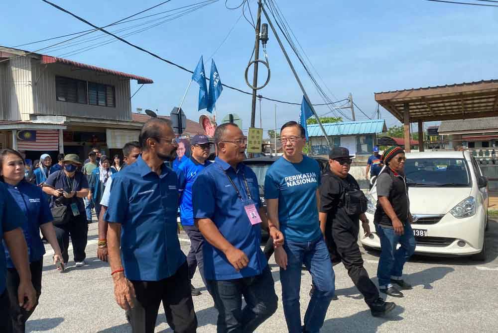 Dominic (kanan) bersama calon PN, Khairul Azhari ketika berkempen di sekitar Kampung Baharu Kerling pada Jumaat.