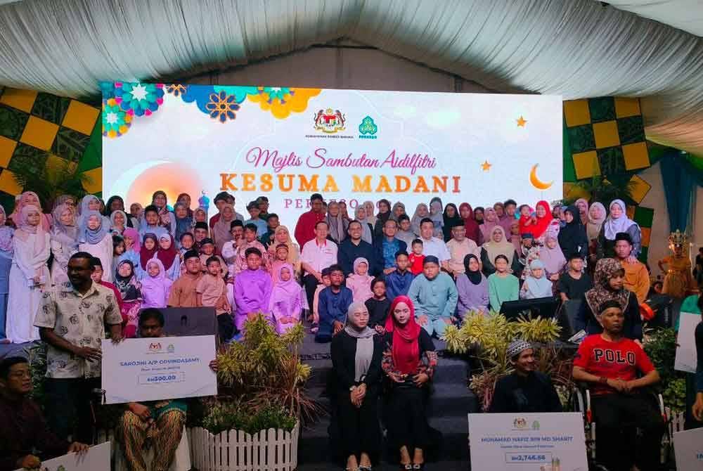 Steven Sim (tengah) bergambar bersama anak yatim dan ibu tunggal yang diraikan.