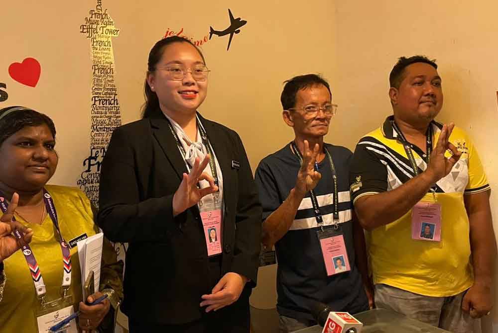 Ke Xin (dua dari kiri) bersama pasukan kempennya selepas melancarkan manifesto di pekan Kuala Kubu Baharu di sini pada Sabtu.