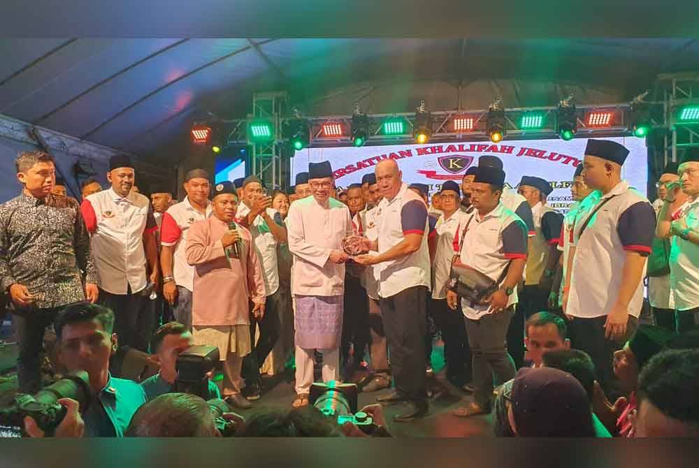 Anwar menerima cenderamata daripada Penasihat Persatuan Khalifah Jelutong, Sulaiman Saad (tiga dari kanan) pada Rumah Terbuka Aidilfitri anjuran Persatuan Khalifah Jelutong malam ini.