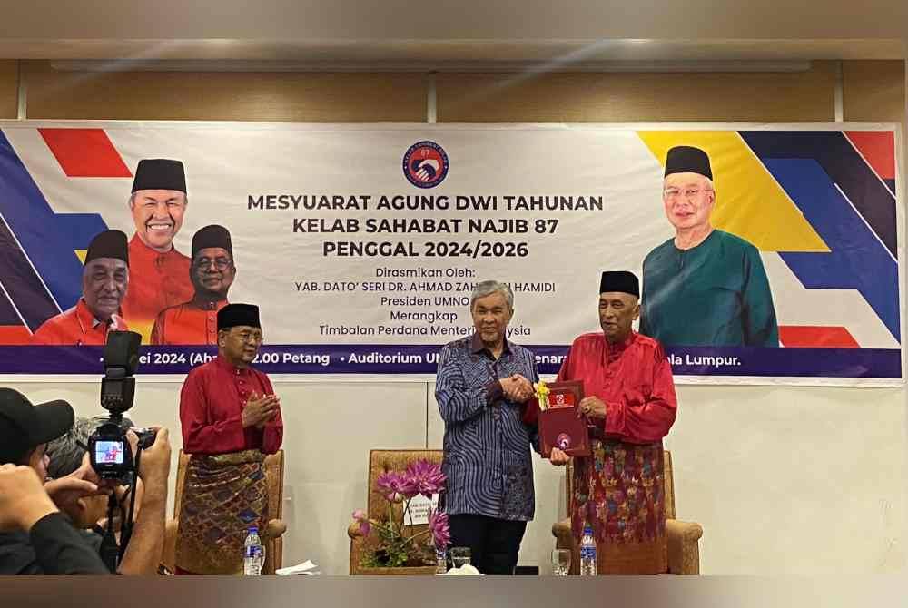 Kamarudin (kanan) menyampaikan resolusi kepada Ahmad Zahid sambil disaksikan Rahman sebelum Mesyuarat Dwi Tahunan Kelab Sahabat Najib 87 di Menara Dato' Onn pada Ahad.