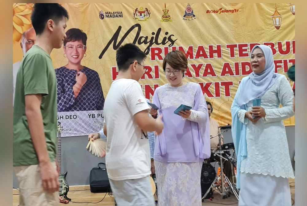 Pei Ling menyampaikan sumbangan duit raya kepada tetamu yang hadir pada Majlis Rumah Terbuka Aidilfitri DUN Bukit Lanjan di Damansara Damai pada Ahad.
