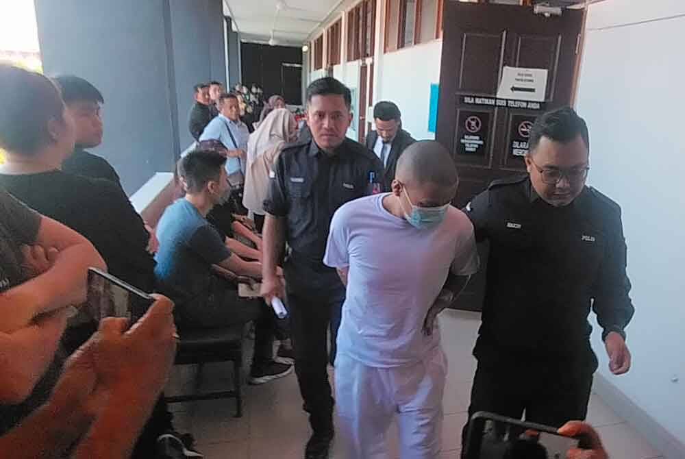 Mohammad Haikal (tengah) dibawa ke Mahkamah Majistret Batu Pahat pada Isnin.