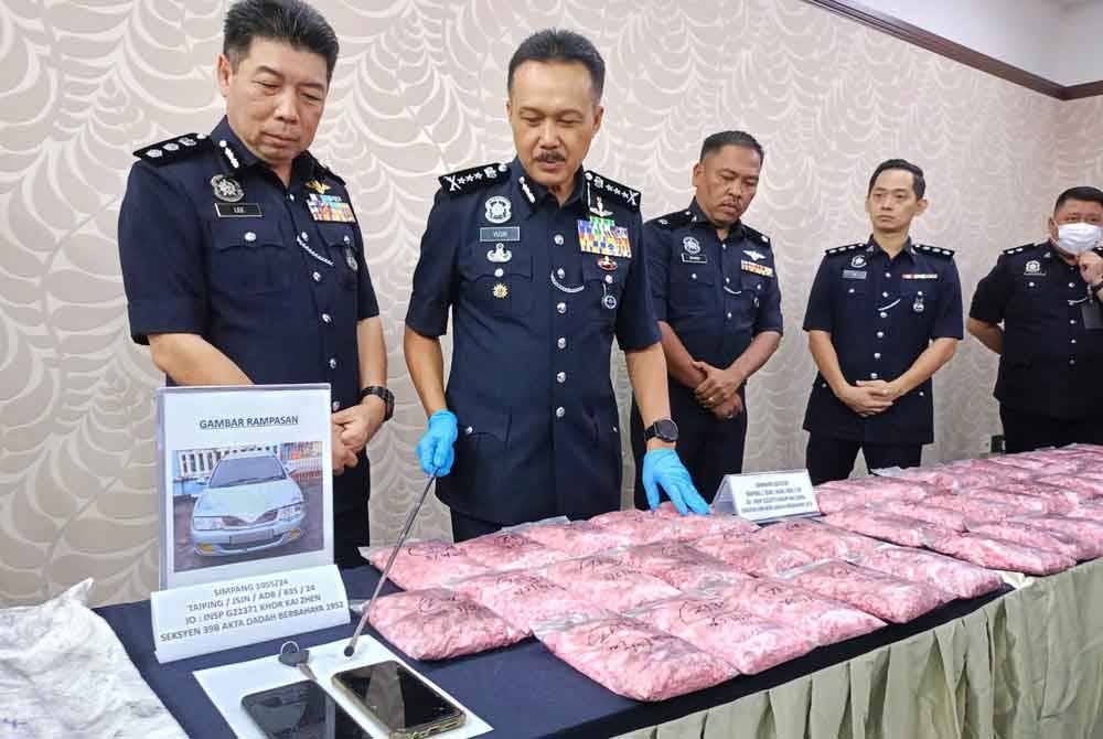 Mohd Yusri (dua dari kiri) menunjukkan rampasan barang kes dan dadah hasil penahanan dua lelaki di Taiping, Jumaat lalu.