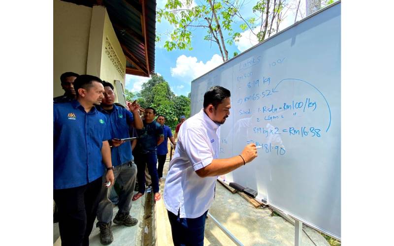 Manndzri membuat kira-kira sambil menerangkan mengenai pengeluaran lateks semasa mengadakan lawatan kerja di Depo Berdang, Tanah Merah, Kelantan.