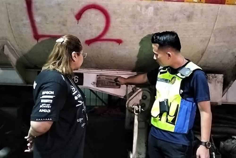 Norena (kanan) melihat lori tangki yang berisi diesel bersubsidi.