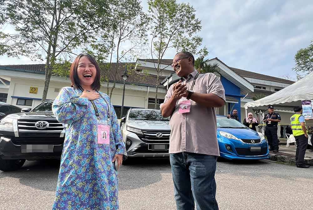 Khairul Azhari (kanan) sempat bertemu calon Pakatan Haran, Pang Sock Tao ketika meninjau proses undi awal di Maktab PDRM pada Selasa.