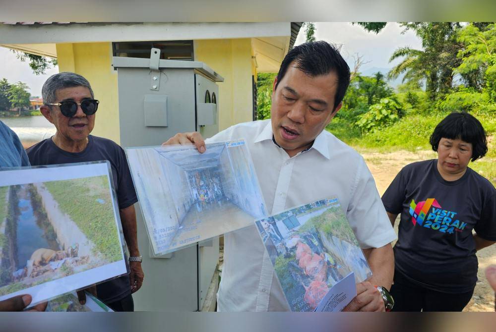 Sze Yee menunjukkan gambar longkang yang tersumbat yang menjadi punca banjir kilat di Sungai Siput.