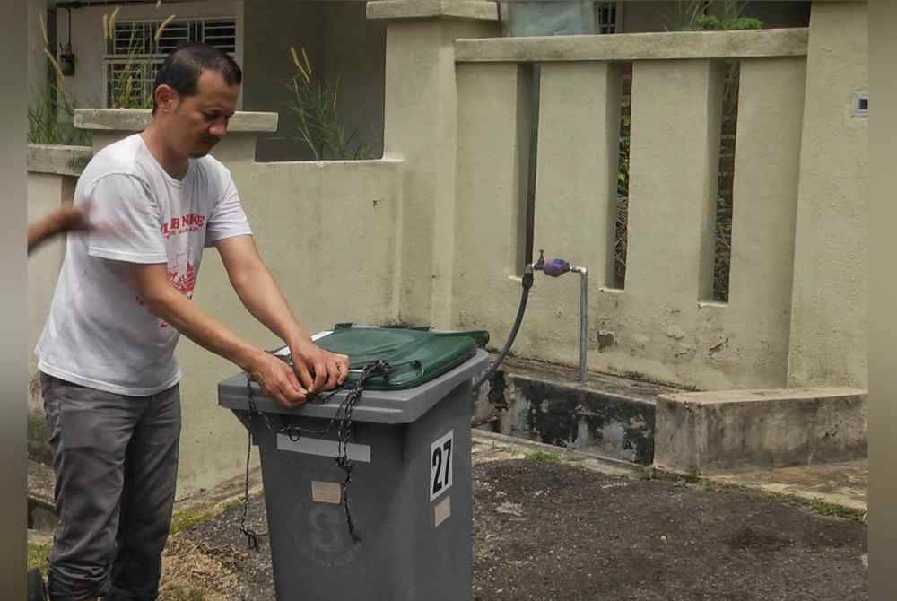 Mohd Akhtar menunjukkan getah dipasang pada tong sampah bagi mengelak diselongkar monyet liar.