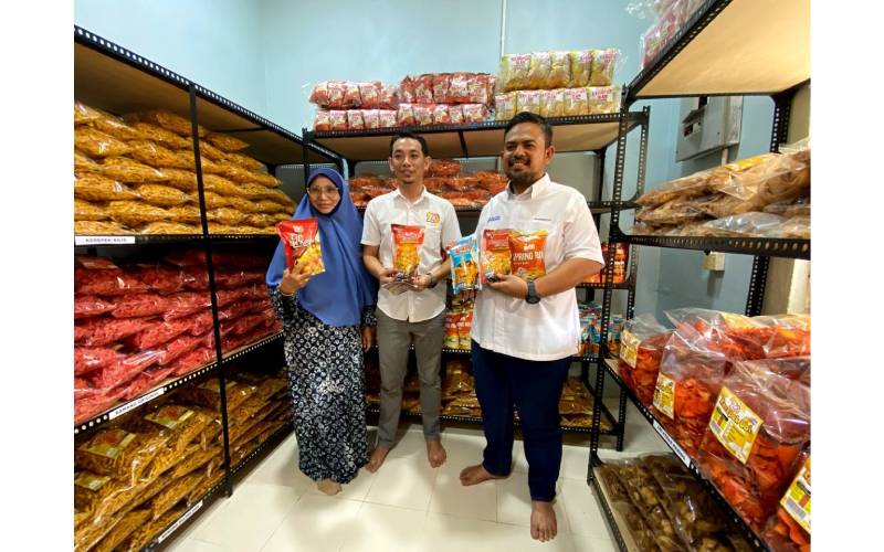Ahmad Asyraf (tengah) bersama Pengerusi RISDA, Manndzri Nasib (kanan) menunjukkan pelbagai produk kerepek yang dihasilkan ZS Maju Products.