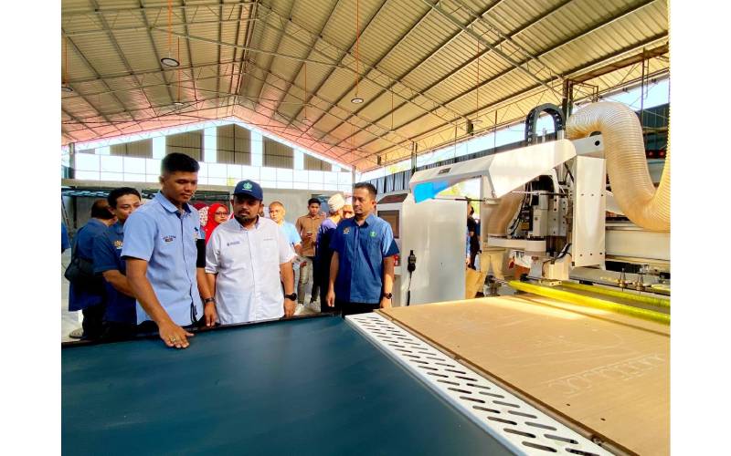 Manndzri (dua dari kanan) mendengar penerangan daripada Muhammad Asyraf (kiri) mengenai operasi mesin kerja kayu ketika melawat syarikat MA Land Resources Sdn Bhd, Kota Bharu, Kelantan.