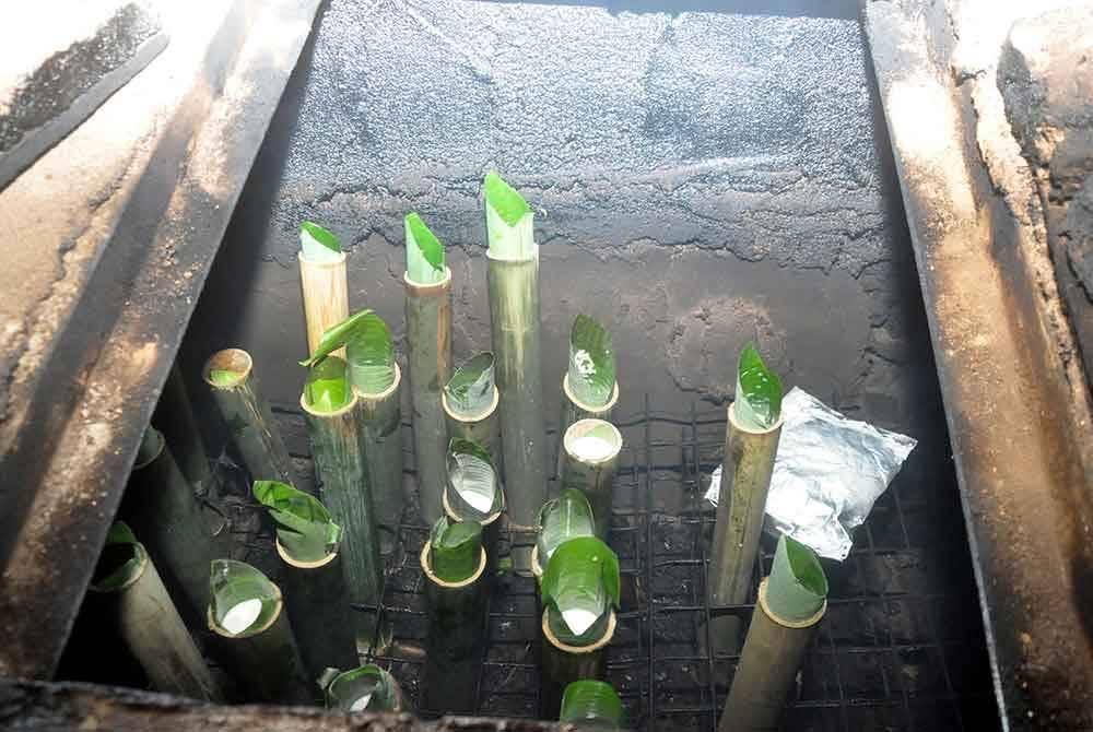 Peniaga lemang, Mohd Zailani Mohd Nor, 49, memasukkan lemang ke dalam dapur relau ciptaannya ketika ditemui di rumahnya di Kampung Alor Belanga dekat Kampung Alor Keladi.