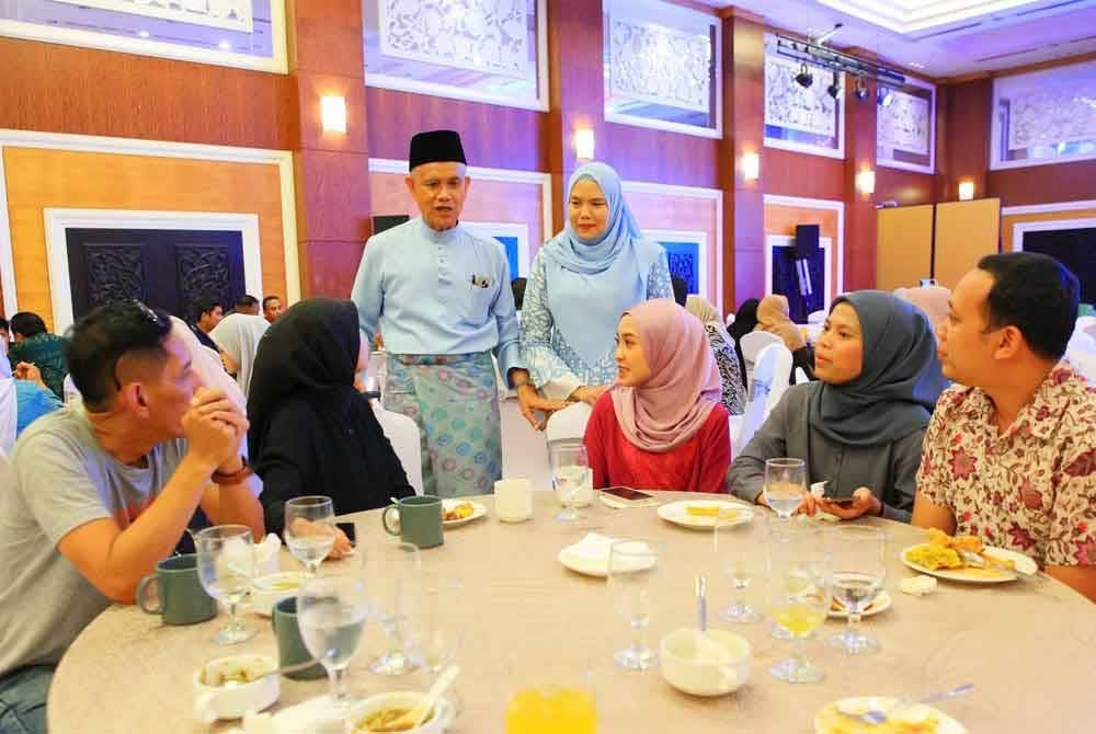 Che Ibrahim (kiri) meyantuni tetamu yang hadir pada Majlis Sambutan Aidilfitri E-Mutiara di Kota Bharu pada Rabu.