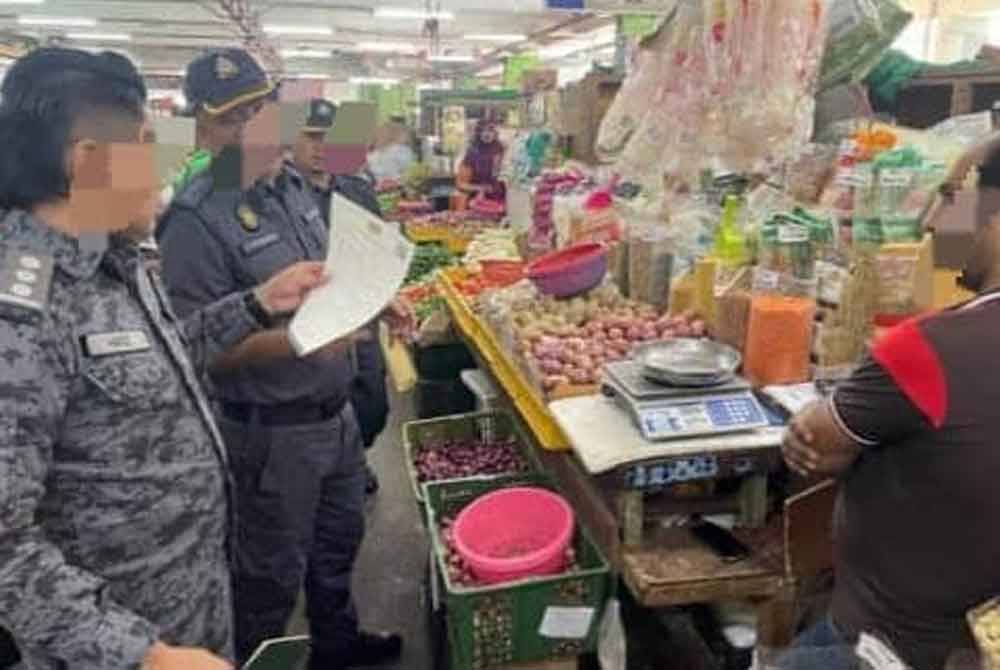 Pegawai Imigresen sedang memeriksa warga asing dalam Ops Belanja yang dilaksanakan di sekitar Bandaraya Ipoh pada Khamis.