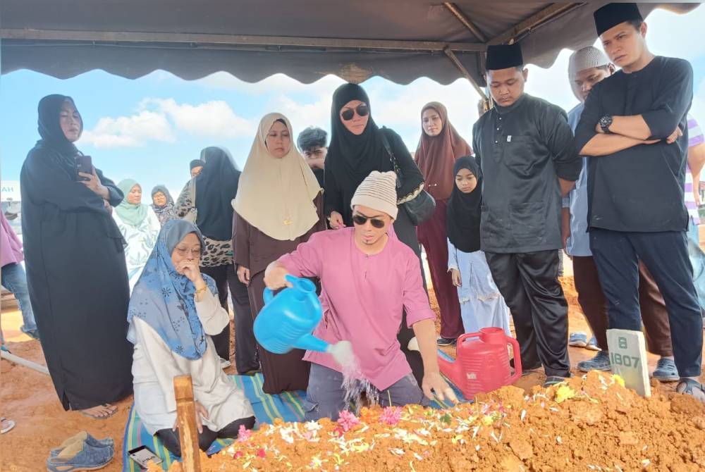 Fizree menyiram pusara ayahnya di Tanah Perkuburan Islam Mutmainnah Pasir Gudang, Pasir Gudang pada Khamis.