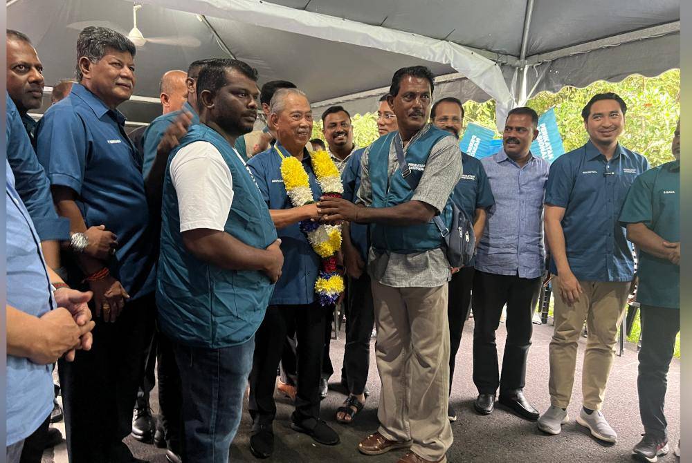 Muhyiddin menerima kalungan bunga daripada penyokong ketika program ramah mesra kaum India di Batang Kali pada Khamis