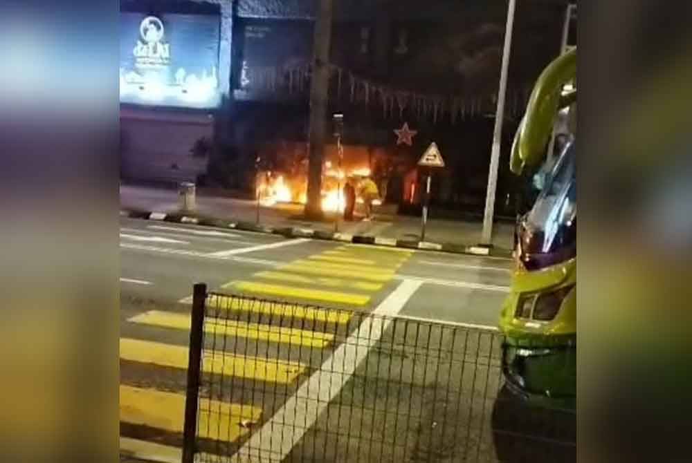 Tangkap layar video tular memaparkan beberapa individu cuba memadamkan kebakaran di hadapan sebuah pusat hiburan dekat Jalan Yap Kwan Seng pada Khamis.