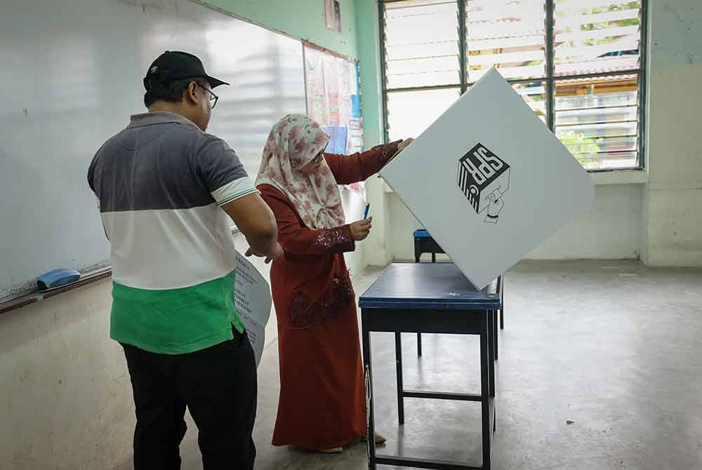 Petugas SPR membuat persiapan di saluran tempat mengundi sempena PRK DUN Kuala Kubu Baharu di Sekolah Menengah Kebangsaan Ampang Pecah, Kuala Kubu Baharu hari ini. Foto Bernama