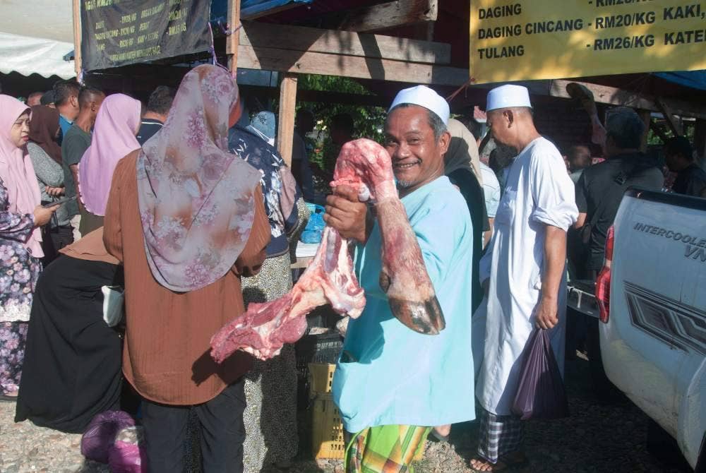 Seorang pembeli membeli kaki lembu yang dijual dengan harga RM50 setiap satu selain membeli daging segar yang dijual hanya RM18 sekilogram di Gong Kemuntong pada Rabu. Foto Bernama