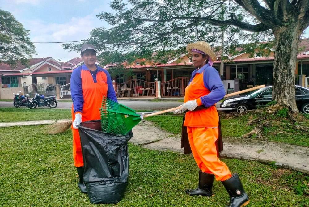 Selve (kiri) bersama rakan baiknya ketika menjalankan kerja-kerja pembersihan di Taman Meranti Lestari, Alor Gajah, Melaka.