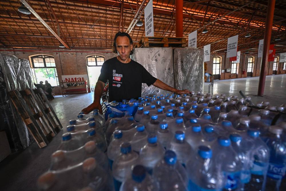 Seorang sukarelawan menyediakan air minuman untuk diagihkan kepada mangsa banjir.