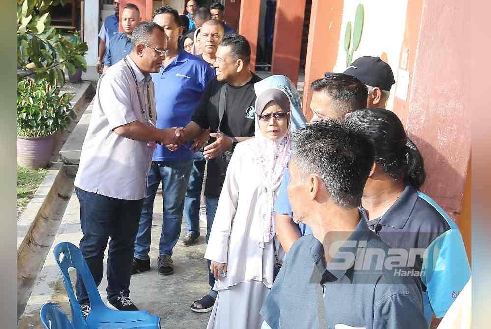 Calon PN, Khairul Azhari (kiri) ketika melawat proses pengundian di SK Bandar Baru Batang Kali sempena PRK Kuala Kubu Bharu pada Sabtu.