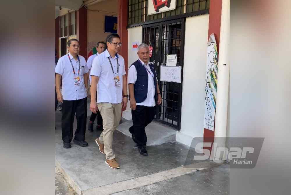 Azmi (dua dari kanan) ketika meninjau proses undi di SMK Kuala Kubu Baharu pada Sabtu.