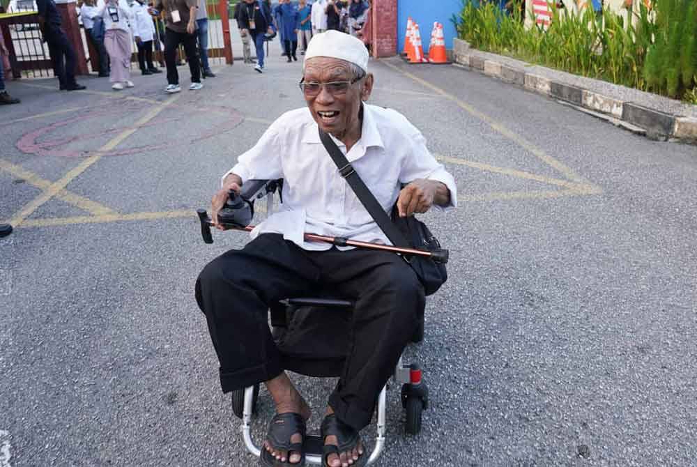 Rosli menaiki kerusi roda elektrik dari rumahnya di Seksyen 3 Bandar Utama Batang Kali ke pusat undi Sekolah Kebangsaan (SK) Bandar Baru Batang Kali di sini pada Sabtu.