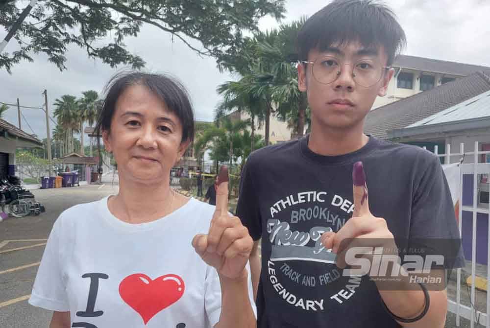 Ji Ming (kanan) ditemani ibunya selesai menunaikan tanggungjawab mengundi di SMK Ampang Pecah (Bestari) pada Sabtu.