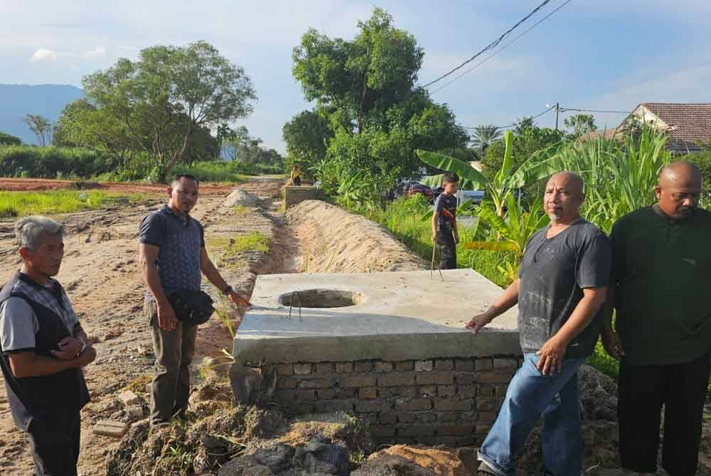 Penduduk menunjukkan benteng pasir yang dibina pemaju beberapa hari lalu didakwa tidak akan bertahan lama bagi mengelakkan kejadian banjir kilat berulang.