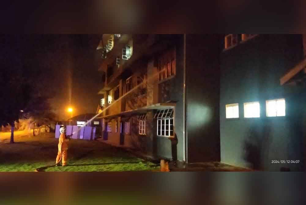 Anggota bomba memadamkan kebakaran melibatkan bilik asrama menempatkan 10 pelajar lelaki. Foto JBPM