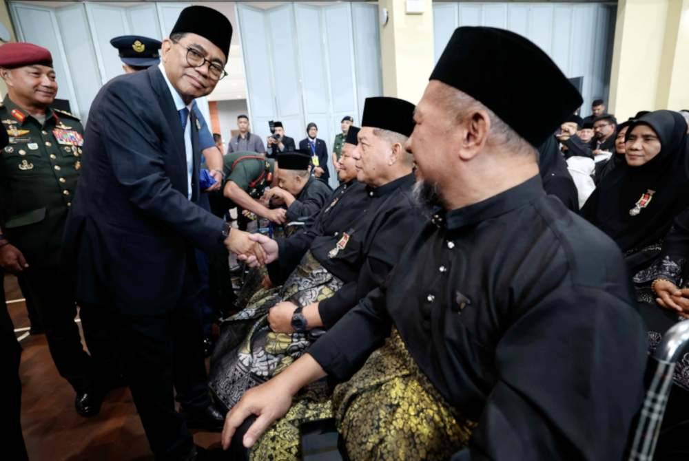 Mohamed Khaled menyematkan Pingat Jasa Malaysia (PJM) kepada veteran ATM, Sarjan (B) Ibrahim Abdul Rahman Pada Majlis Penganugerahan PJM Tahun 2024 di Dewan Taman Pulai Utama pada Ahad. Foto Bernama