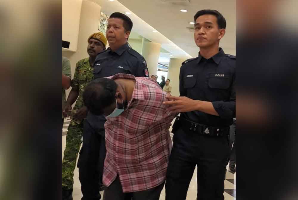 Ganasean (tengah) ketika dibawa ke Mahkamah Majistret Kuala Lumpur pada Isnin.