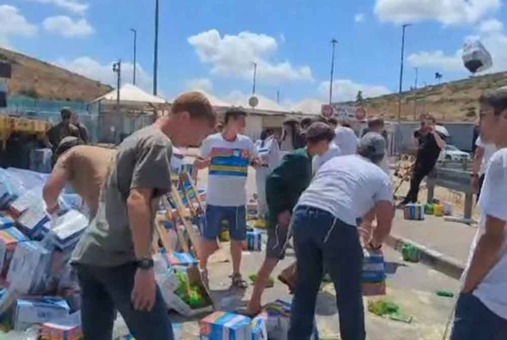 Video yang tular di media sosial menunjukkan penunjuk perasaan membuang bekalan dari trak ke tanah. - Foto Reuters