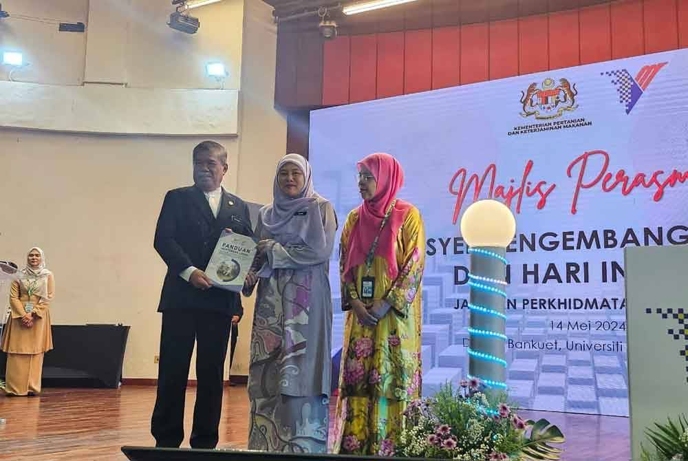 Mohamad Sabu (kiri) dan Akma (tengah) melancarkan buku Panduan Menternak Lembu Pedaging Secara Berintegrasi Bersistematik dalam Kadang Kelapa Sawit di Dewan Bankuet UPM pada Selasa.