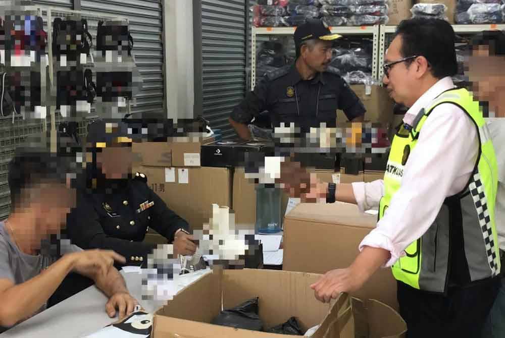Serbuan di sebuah premis yang menjalankan aktiviti pemborong dan menjual kasut tiruan dalam talian di Ipoh. Foto ihsan KPDN Perak