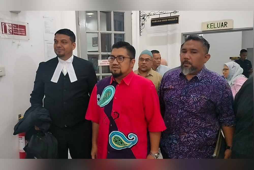 Che'gu Bard (tengah) bersama Muhammad Rafique (kiri) keluar dari Mahkamah Tinggi Johor pada Khamis.