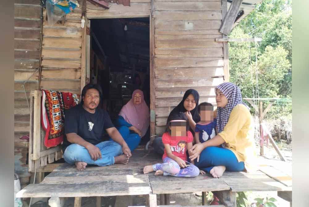 Siti Zulaikha Asyikin (kanan) bersama suami (kiri) dan anak-anak mereka ketika ditemui di Kampung Cawat, baru-baru ini.